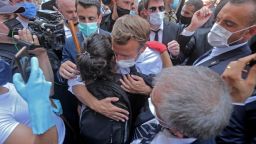 TOPSHOT - A Lebanese youth hugs French President Emmanuel Macron during a visit to the Gemmayzeh neighborhood, which has suffered extensive damage due to a massive explosion in the Lebanese capital, on August 6, 2020. - French President Emmanuel Macron visited shell-shocked Beirut, pledging support and urging change after a massive explosion devastated the Lebanese capital in a disaster that has sparked grief and fury. (Photo by - / AFP) (Photo by -/AFP via Getty Images)
