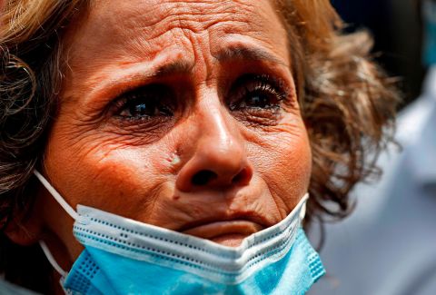 A woman, whose son was said to be missing after the explosion, waits outside Beirut's port to receive information from rescue teams.