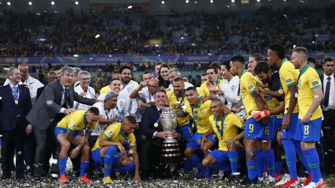  President of Brazil Jair Bolsonaro celebrates with the trophy and the players of Brazil after winning the Copa America final against Peru.