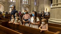 NEW YORK, UNITED STATES - 2020/06/28: A family with kids prays during St. Patrick's Cathedral Sunday first public Mass since March, when it stopped in-person attendance during the Covid-19 coronavirus pandemic. Attendance was limited to 25 percent capacity and social distancing was enforced with pews marked with green and red dots, where green was used to allow single or the same family sit. Mass was available via livestream as well. Timothy Dolan, Cardinal and Archbishop of New York led the mass. (Photo by Lev Radin/Pacific Press/LightRocket via Getty Images)