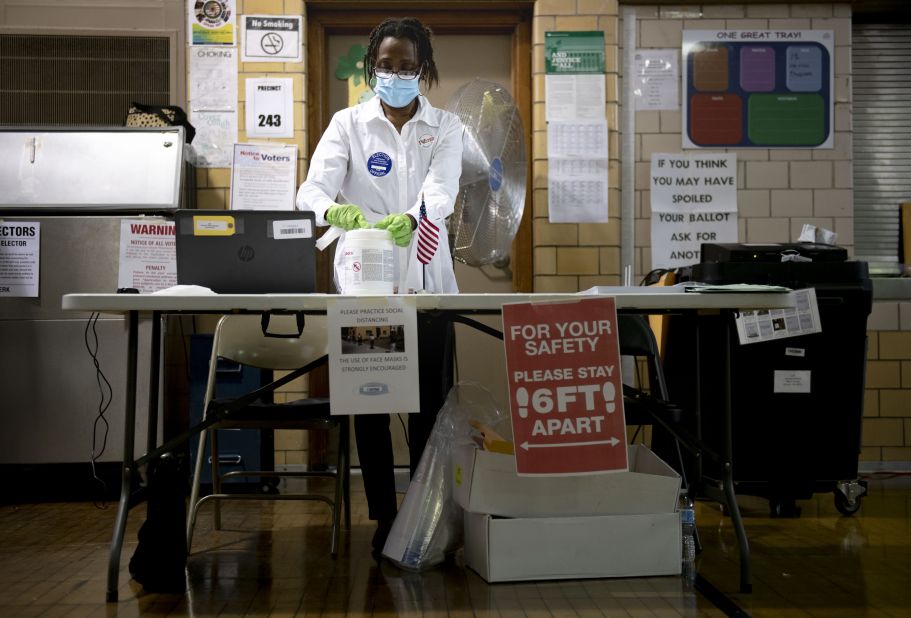 Poll worker Debra Moore sanitizes her workspace during a primary election in Detroit on August 4.