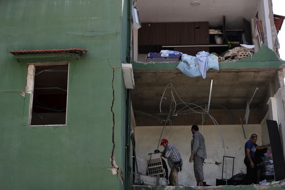 People remove debris from a house on August 7, 2020.