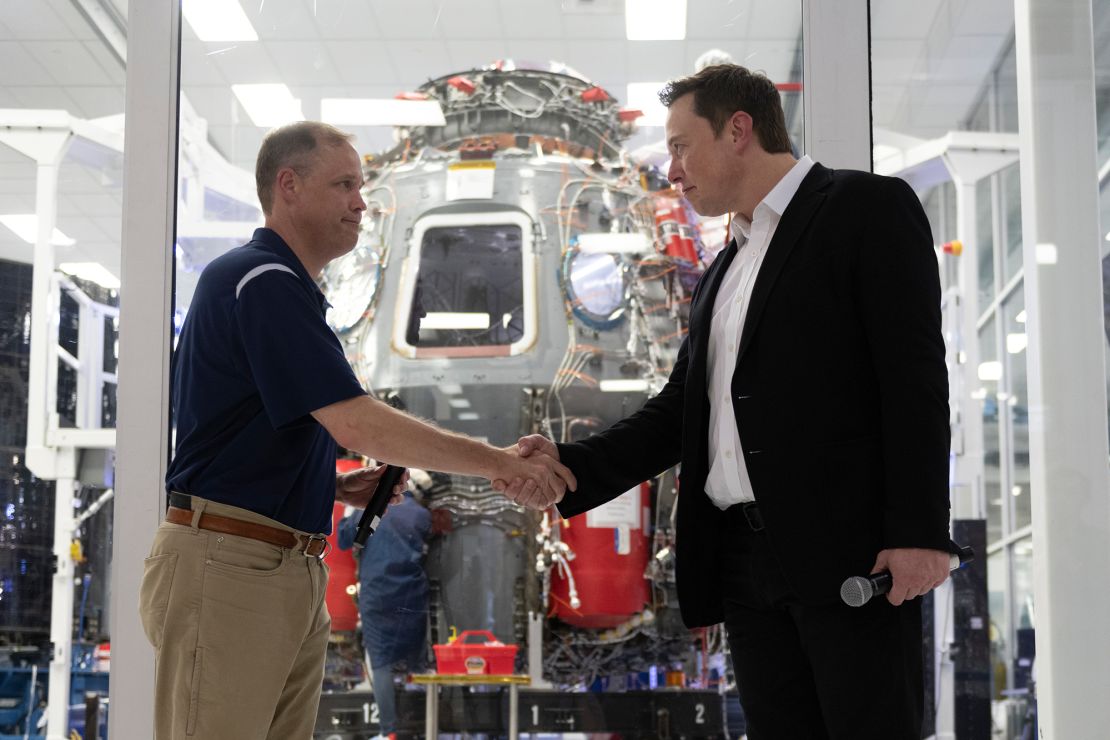 NASA administrator Jim Bridenstine and Elon Musk shake hands in front of Crew Dragon cleanroom at SpaceX Headquarters in Hawthorne, California on October 10, 2019.