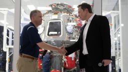 NASA administrator Jim Bridenstine and Elon Musk shake hands in front of Crew Dragon cleanroom at SpaceX Headquarters in Hawthorne, California on October 10, 2019.