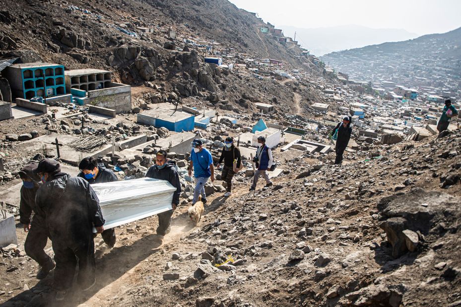 Cemetery workers carry the coffin of a Covid-19 victim at a graveyard in Comas, Peru, on August 5.