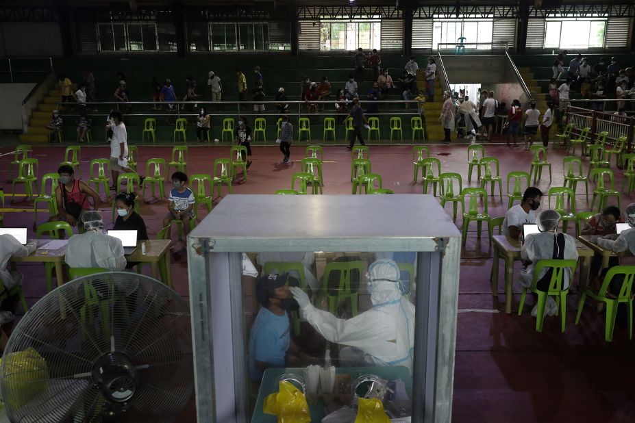 A health worker performs a Covid-19 test at a gymnasium in Navotas, Philippines, on August 6.