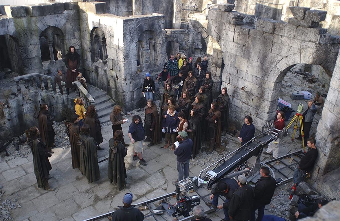 Shah (top left) on the set of "The Lord of the Rings," among the cast and crew receiving direction from Peter Jackson (center).