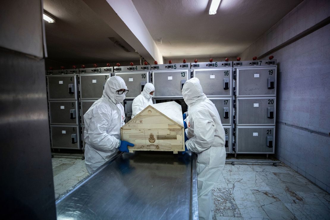 Officials with protective suits carry a coffin of a coronavirus victim before the process of ghusl, washing and shrouding the body, ahead of a Muslim funeral ceremony in Istanbul, Turkey, on May 10, 2020. 