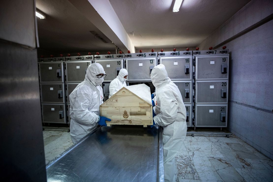 Officials with protective suits carry a coffin of a coronavirus victim before the process of ghusl, washing and shrouding the body, ahead of a Muslim funeral ceremony in Istanbul, Turkey, on May 10, 2020.