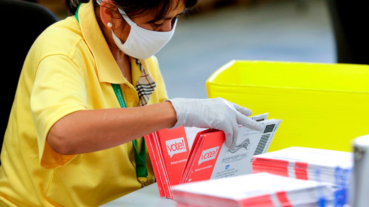 An election worker opens envelopes containing vote-by-mail ballots for the August 4 Washington state primary at King County Elections in Renton, Washington on August 3, 2020.A sign explaining signature verification is pictured as vote-by-mail ballots for the August 4 Washington state primary are processed at King County Elections in Renton, Washington on August 3, 2020. (Photo by Jason Redmond / AFP) (Photo by JASON REDMOND/AFP via Getty Images)