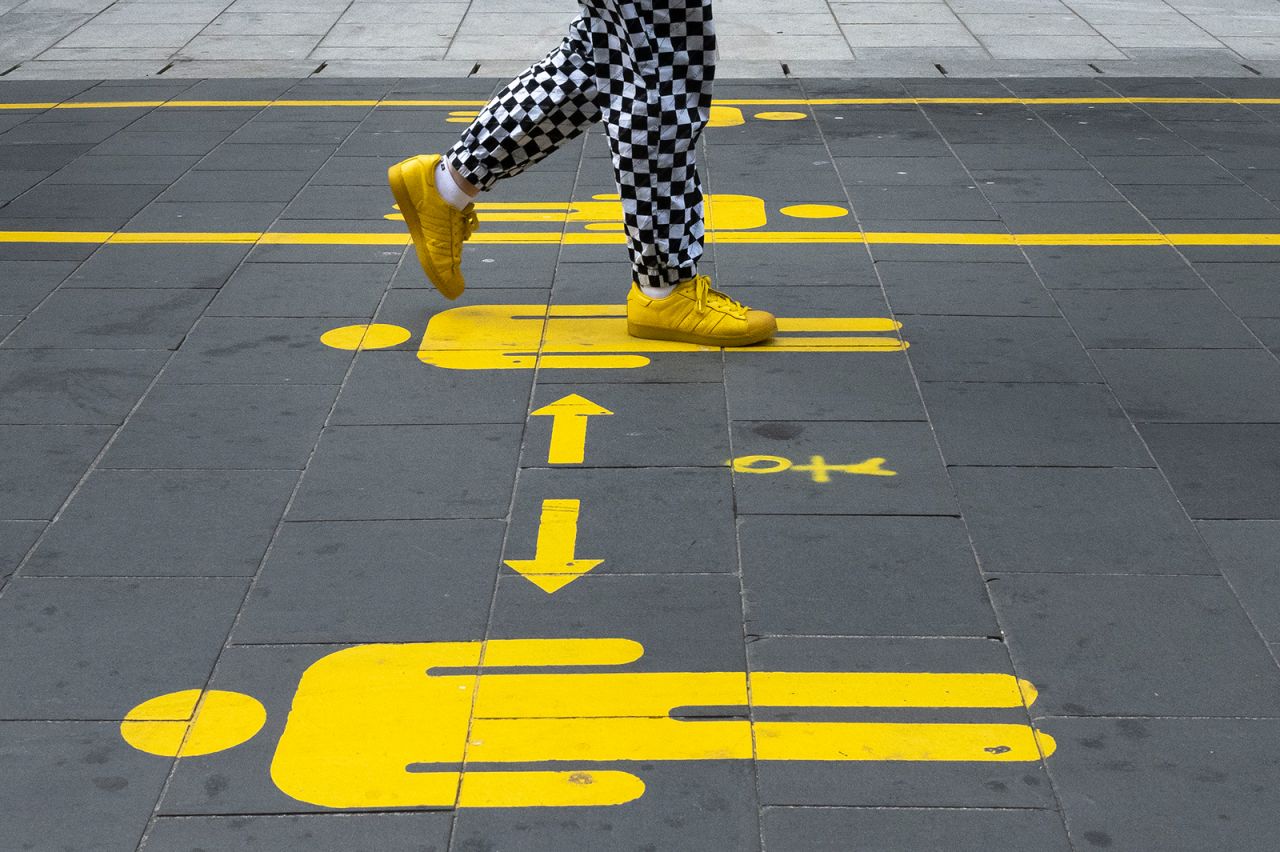 A woman in Cardiff, Wales, walks on St. Mary's Street, where social-distancing markers were painted on August 4.