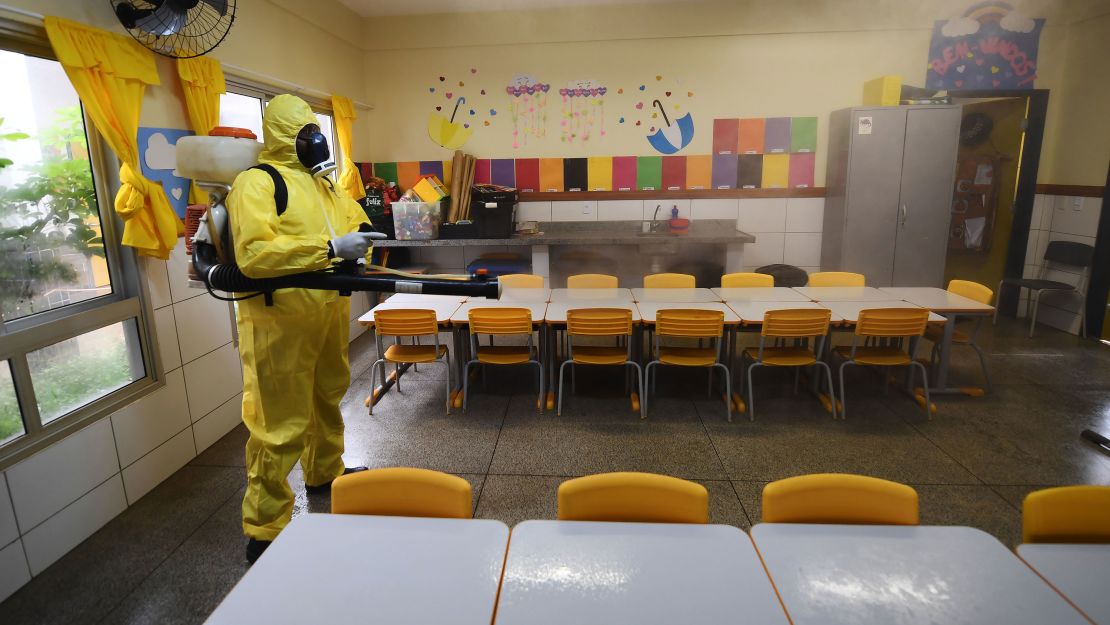 A Federal District employee disinfects a public school as a measure against the spread of the coronavirus in Brasilia, on August 5, 2020.