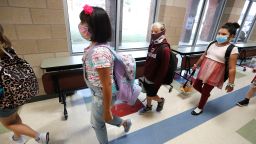 Wearing masks to prevent the spread of COVID19, elementary school students walk to class to begin their school day in Godley, Texas, Wednesday, Aug. 5, 2020. Three rural school districts in Johnson County were among the first in Texas to head back to school for in person classes for students. (AP Photo/LM Otero)