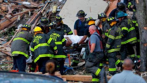 Firefighters carry someone from the debris in Baltimore on Monday.