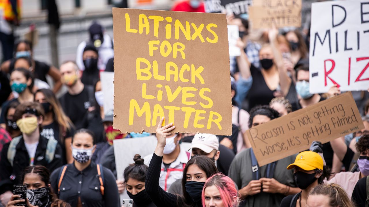 A protester holds a sign that reads, "LATiNXS FOR BLACK LiVES MATTER" in New York on June 2.