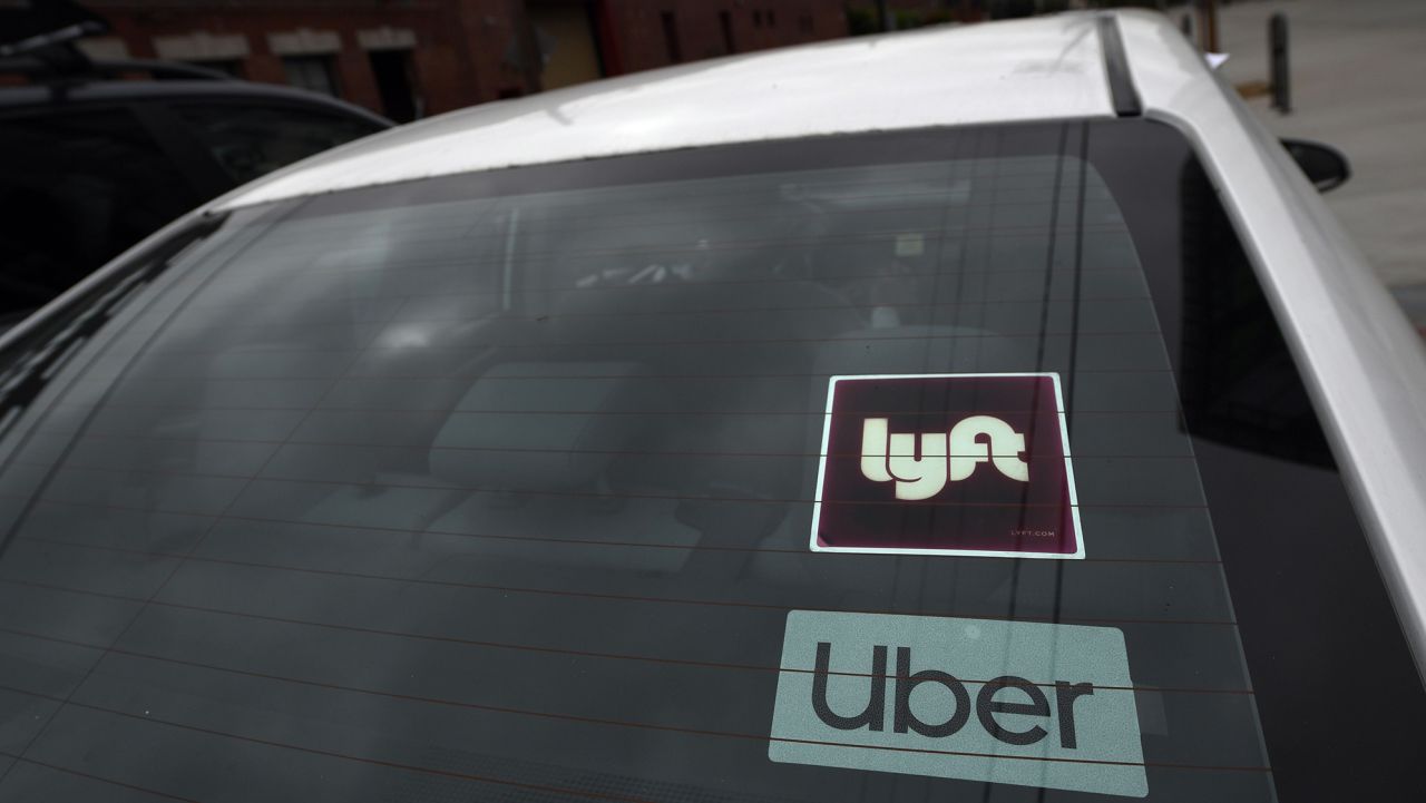 Rideshare drivers demonstrate against rideshare companies Uber and Lyft during a car caravan protest on August 6, 2020 in Los Angeles. - The drivers, organized by the Mobile Workers Alliance and Rideshare Drivers United unions, say Uber and Lyft's are pushing a "deceptive" November ballot initiative, which, if passed, they claim would "rewrite labor law" and turn app-based drivers into independent contractors, exempting companies such as Lyft and Uber from standard wage and hour restrictions. (Photo by Robyn Beck/AFP/Getty Images)