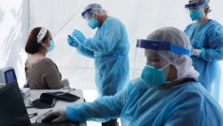 St. John's Well Child & Family Center workers prepare to test a woman for COVID-19 at a free mobile test clinic set up outside Walker Temple AME Church in South Los Angeles amid the coronavirus pandemic on July 15, 2020 in Los Angeles, California. (Photo by Mario Tama/Getty Images)