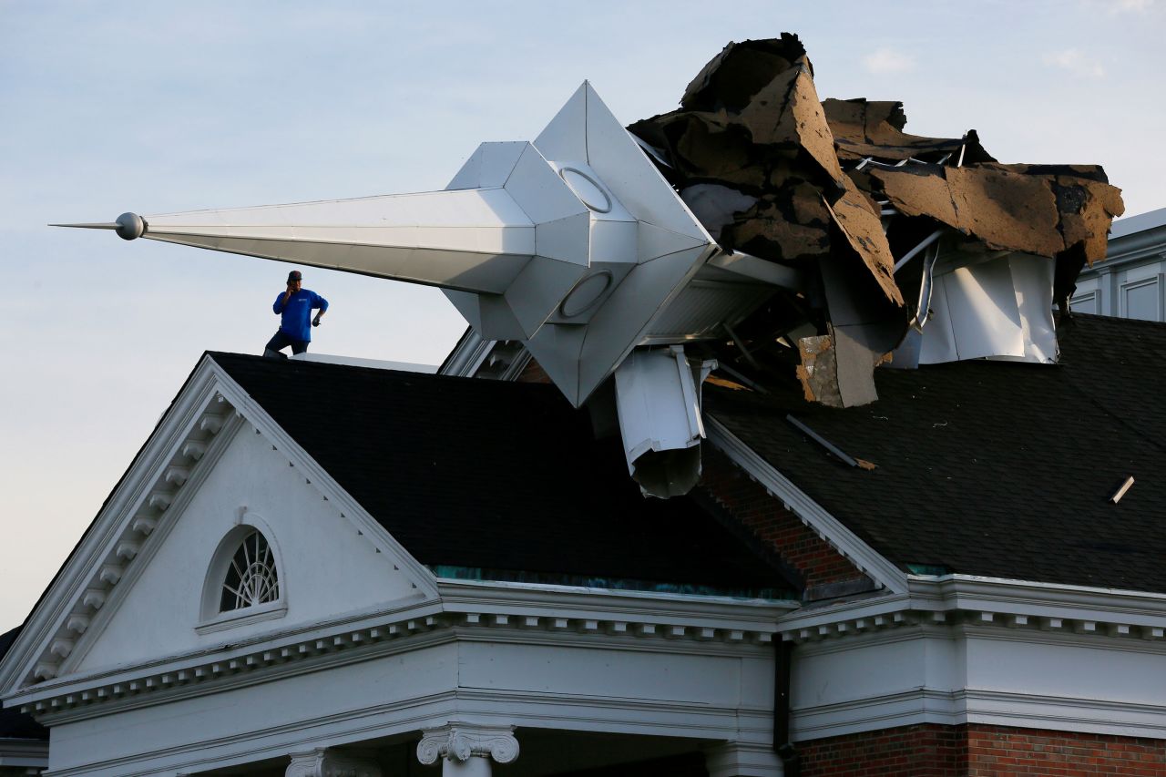 A person surveys damage from the roof of College Church after a severe storm toppled the church's steeple in Wheaton, Illinois, on Monday, August 10.