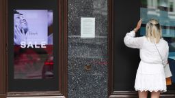 A shopper looks into a window outside Harrods department store in London, Wednesday, July 1, 2020. Companies linked to hospitality and travel in Britain are shedding thousands of jobs as the longer term consequences of the COVID-19 pandemic take hold, choosing to slim down for survival rather than await potential government handouts. Even stalwarts such as British shopping icon Harrods reportedly drew plans for 700 cuts, blamed in part on a lack of tourists.(AP Photo/Alastair Grant)