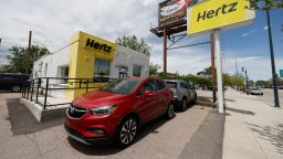 Rental vehicles are parked outside a closed Hertz car rental office Saturday, May 23, 2020, in south Denver. 