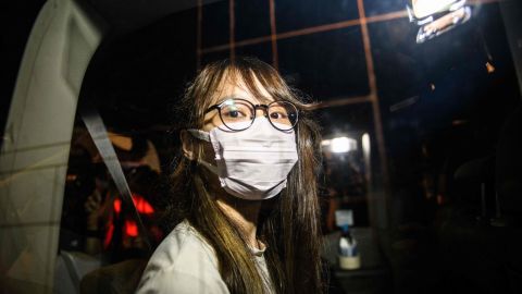 Prominent Hong Kong democracy activist Agnes Chow looks out of a car window while being driven away by police from her home after she was arrested under the new national security law in Hong Kong late on August 10, 2020.