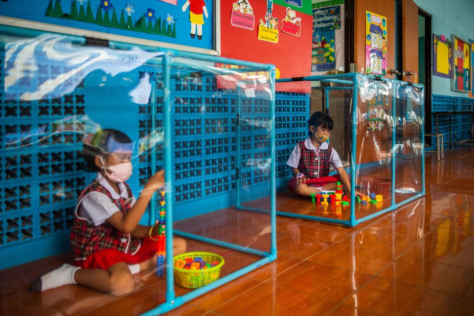Kindergarten students wear face masks and play in screened-in areas at the Wat Khlong Toey School in Bangkok, Thailand, on August 10.