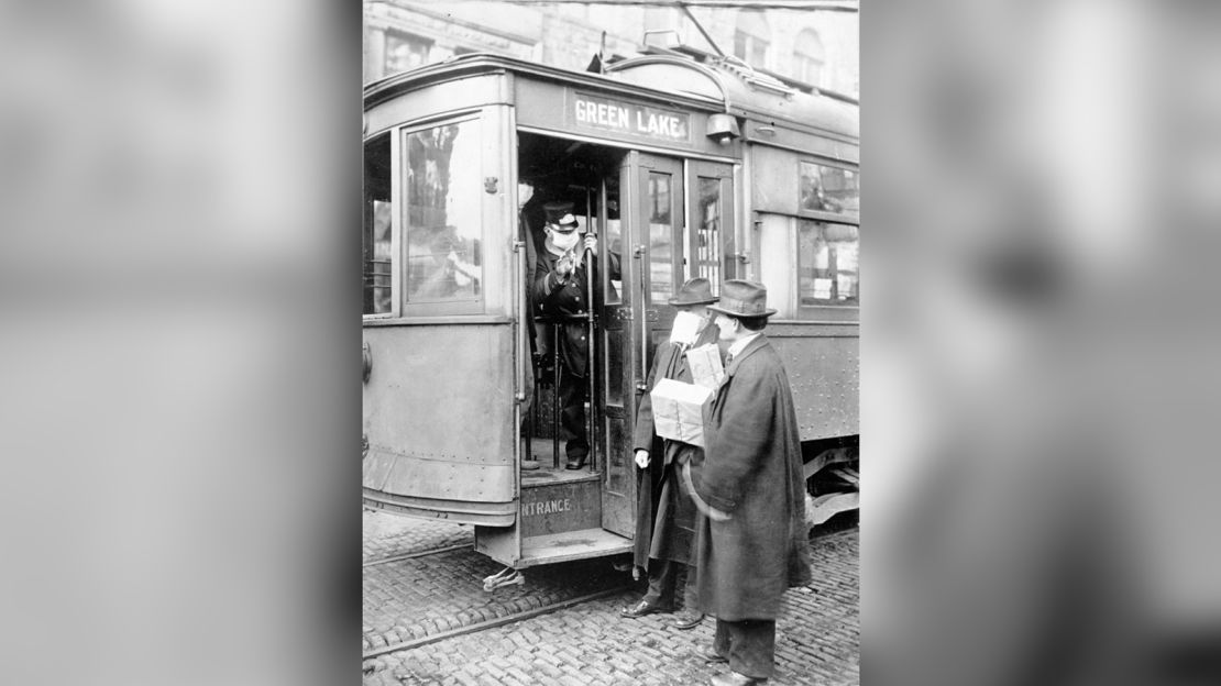 A street car conductor in Seattle not allowing passengers aboard without a mask in 1918.