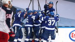 TORONTO, ONTARIO - AUGUST 11: Mikhail Sergachev #98 of the Tampa Bay Lightning celebrates with his team after Brayden Point #21 scored the game winning goal at 10:27 in the fifth overtime to win Game One of the Eastern Conference First Round of the 2020 NHL Stanley Cup Playoff with a score of 3-2 as David Savard #58 of the Columbus Blue Jackets looks on at Scotiabank Arena on August 11, 2020 in Toronto, Ontario. (Photo by Chase Agnello-Dean/NHLI via Getty Images)