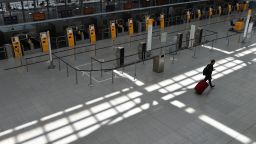 A passenger walks in an empty Lufthansa terminal at the "Franz-Josef-Strauss" airport in Munich, southern Germany, on May 27, 2020. 