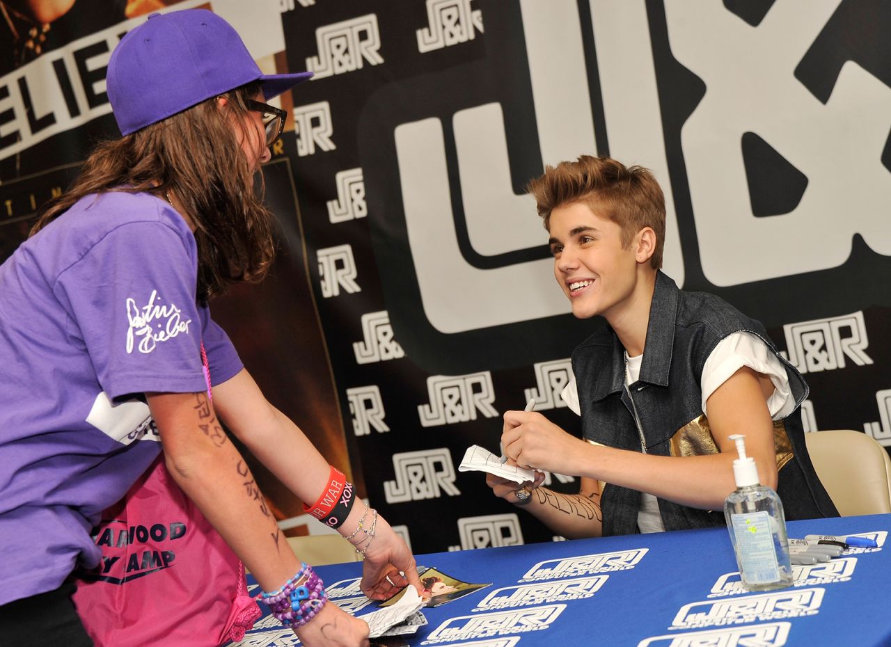 Justin Bieber signs autographs and plays guitar left-handed. 