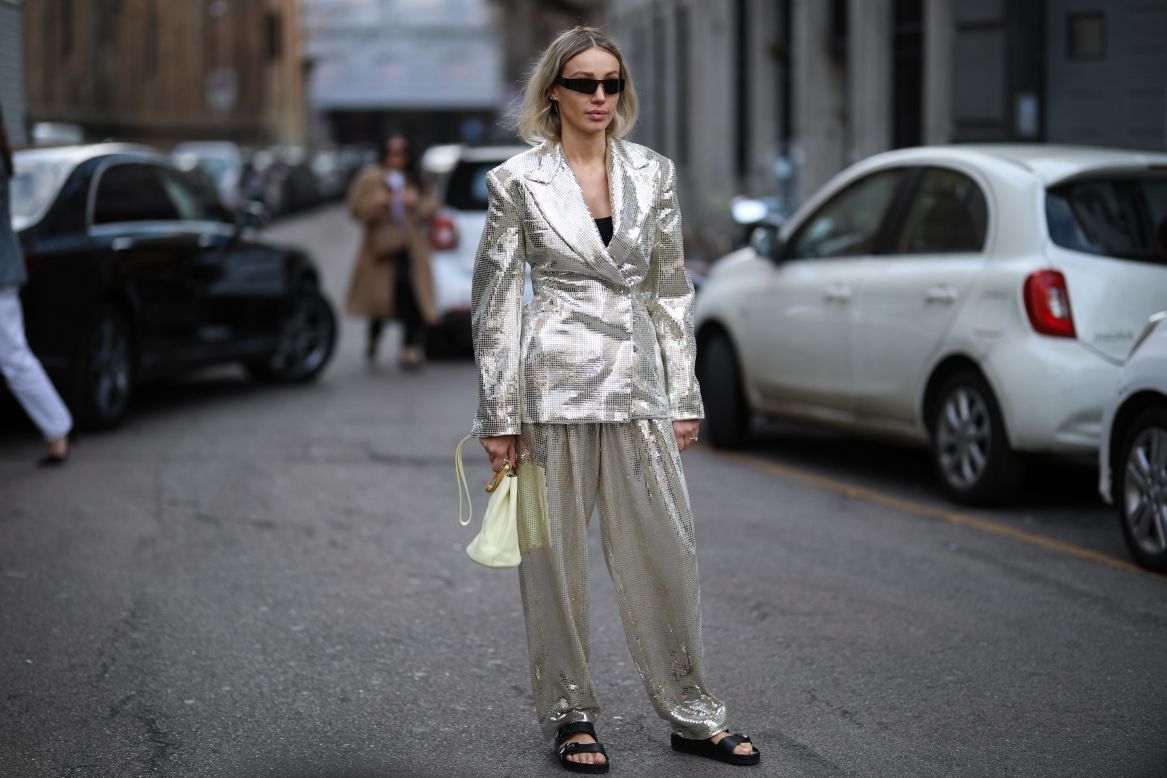 A Milan Fashion Week guest completes a bold metallic ensemble with a pair of Birkenstock sandals.