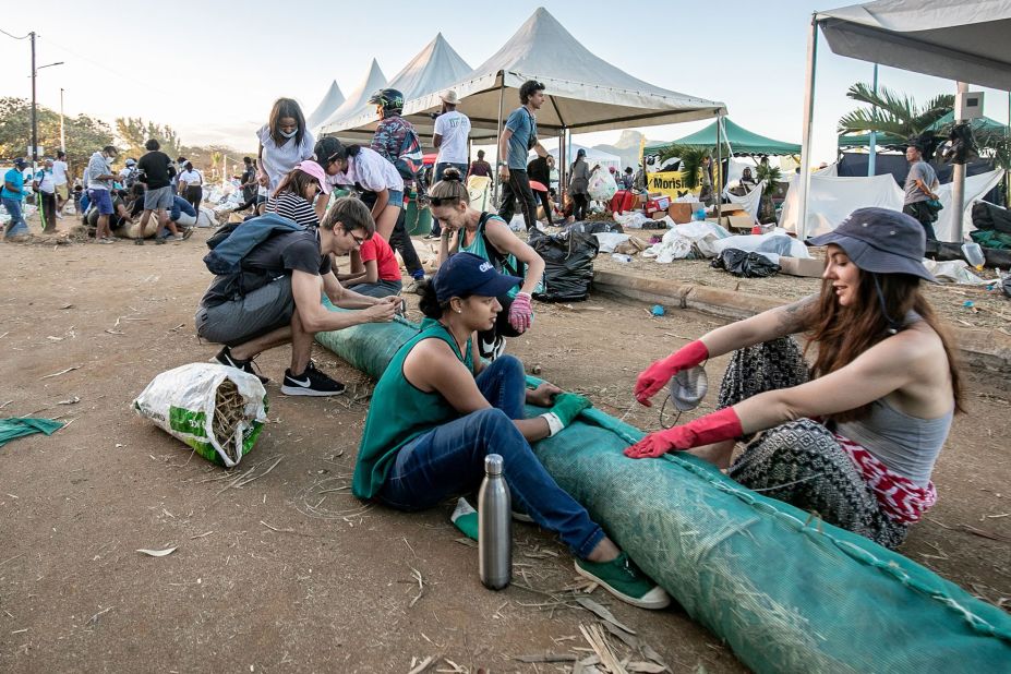 Volunteers make handmade oil barriers at the Mahébourg waterfront on August 12.