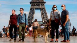 Tourists wearing a protective mask walk a front the Eiffel Tower in France. On August 2, 2020. (Photo by Mehdi Taamallah/NurPhoto via AP)