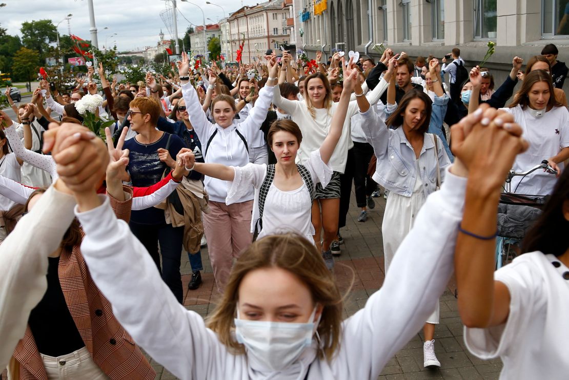 Women wearing white march in Minsk, Belarus on Wednesday, in protest against police violence during recent rallies against the results of the country's presidential election.
