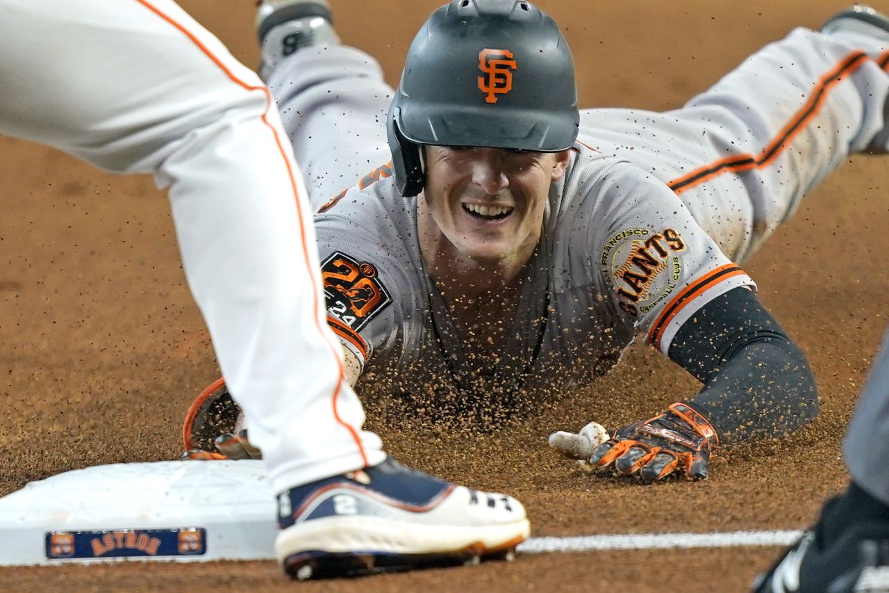 San Francisco's Mike Yastrzemski dives toward third base after hitting a triple during a Major League Baseball game in Houston on Wednesday, August 12.