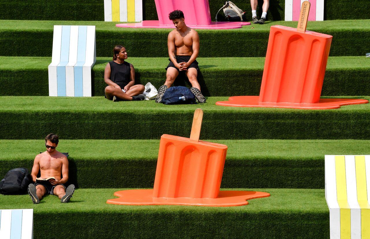 Summer-themed sculptures surround people on a hot day in London on Thursday, August 12.