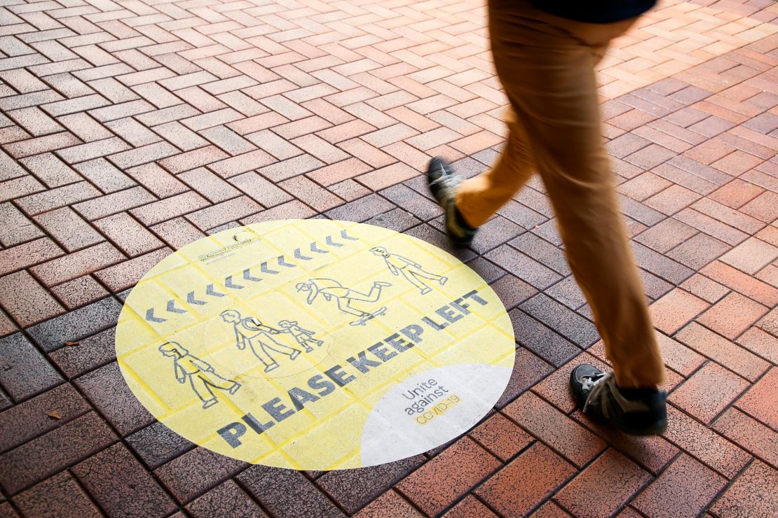 A pedestrian walks past a social distancing sign on August 14, 2020 in Wellington, New Zealand.