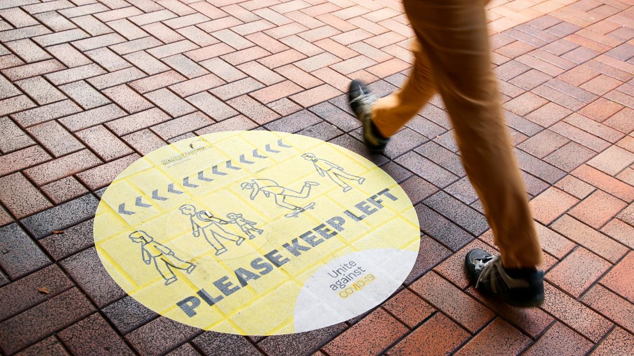 A pedestrian walks past a social distancing sign on August 14, 2020 in Wellington, New Zealand.