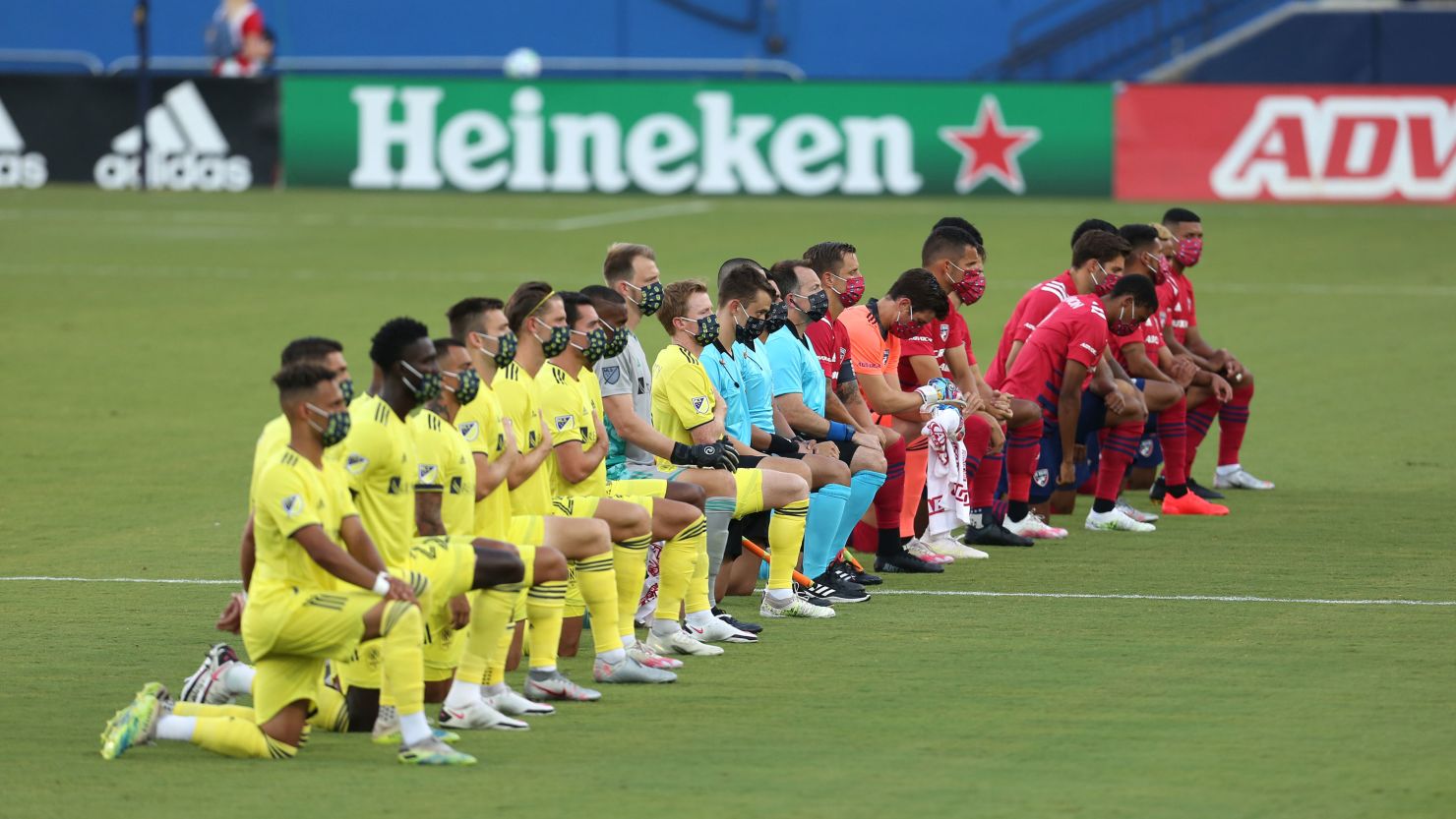 Players of FC Dallas (R) and Nashville SC kneel during the US national anthem before their game in Frisco, Texas.