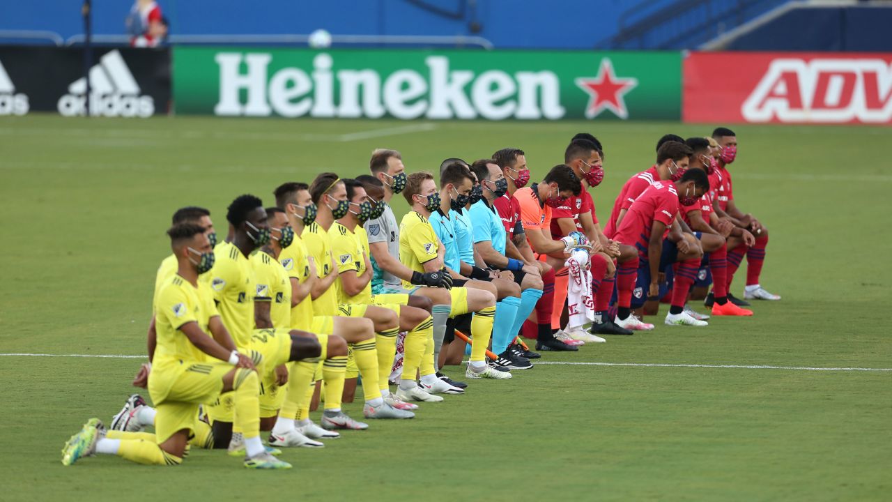 Players of FC Dallas (R) and Nashville SC kneel during the US national anthem before their game in Frisco, Texas.