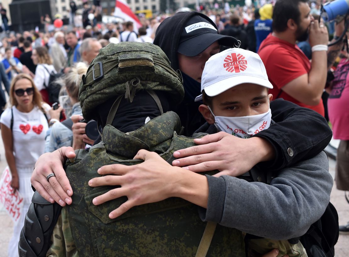 Protesters in Minsk embrace a Belarus law enforcement officer during a rally against President Alexander Lukashenko, who is accused of falsifying the polls in Sunday's election.