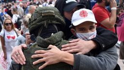 Protesters in Minsk embrace a Belarus law enforcement officer during a rally against President Alexander Lukashenko, who is accused of falsifying the polls in Sunday's election.