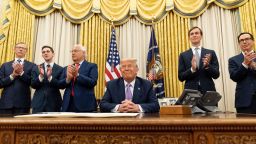 President Donald Trump, accompanied by from left, U.S. special envoy for Iran Brian Hook, Avraham Berkowitz, Assistant to the President and Special Representative for International Negotiations, U.S. Ambassador to Israel David Friedman, Trump's White House senior adviser Jared Kushner, and Treasury Secretary Steven Mnuchin, applaud in the Oval Office at the White House, Wednesday, Aug. 12, 2020, in Washington. Trump said on Thursday that the United Arab Emirates and Israel have agreed to establish full diplomatic ties as part of a deal to halt the annexation of occupied land sought by the Palestinians for their future state.
