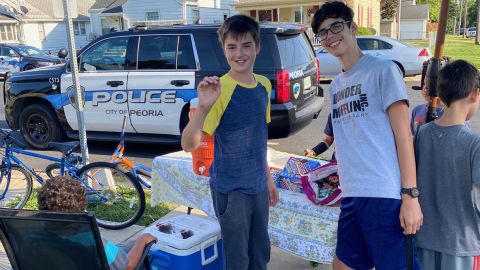 Jude, left, and Tristan, right, at their lemonade stand after they were robbed at gunpoint.