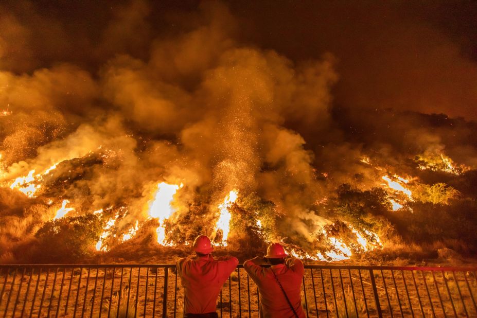 Firefighters look at smoke and flames rising from the Ranch2 Fire in the San Gabriel Mountains, east of Los Angeles, on August 14, 2020.