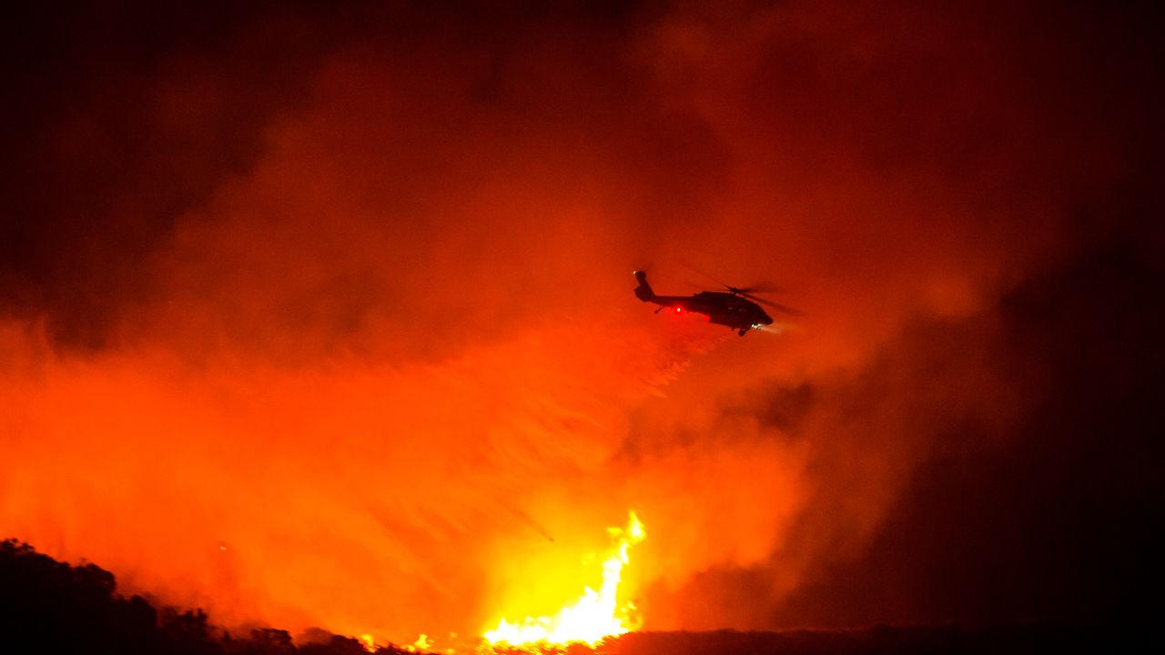 A helicopter drops water on the Lake Hughes fire in Angeles National Forest on Thursday, Aug. 13, 2020, north of Santa Clarita, Calif. (AP Photo/Ringo H.W. Chiu)