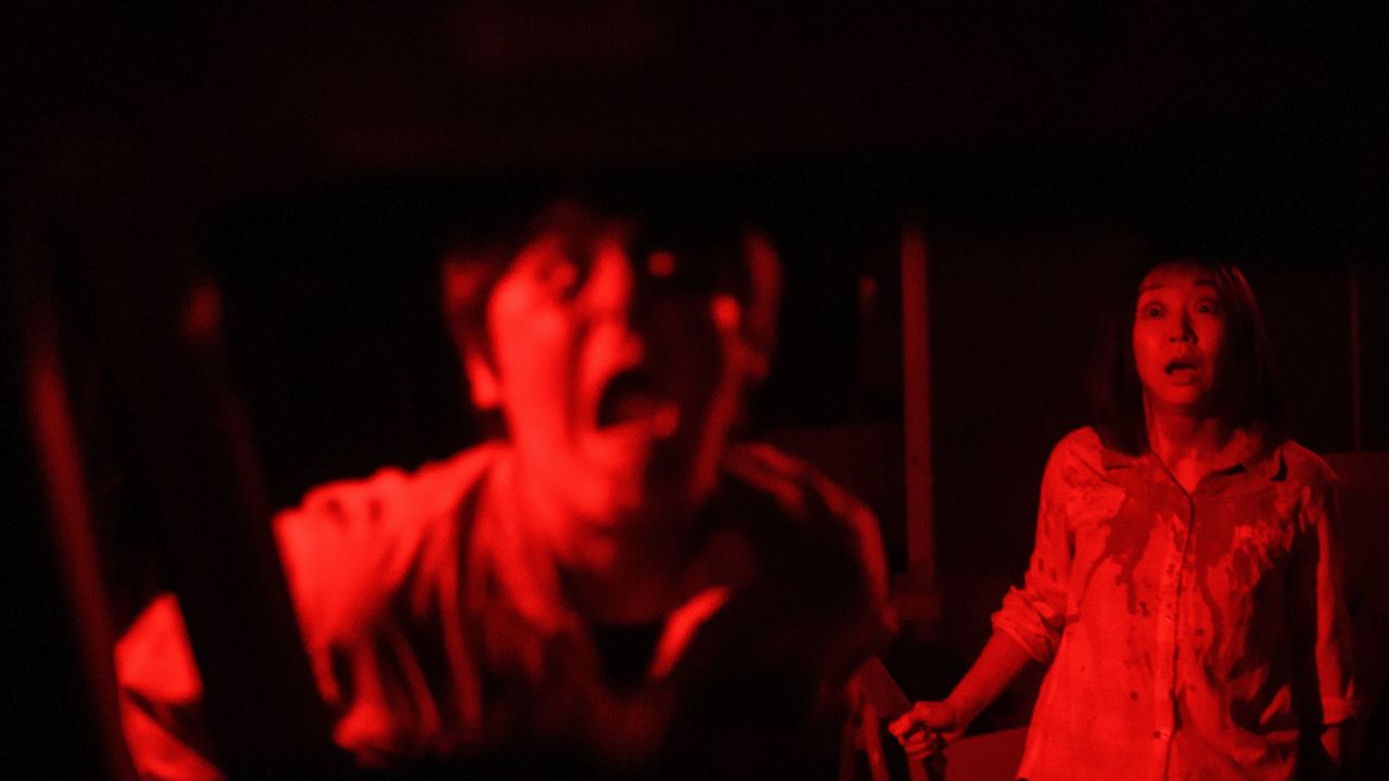 Actors give a red-lighted haunting performance at the drive-in haunted house in Tokyo.