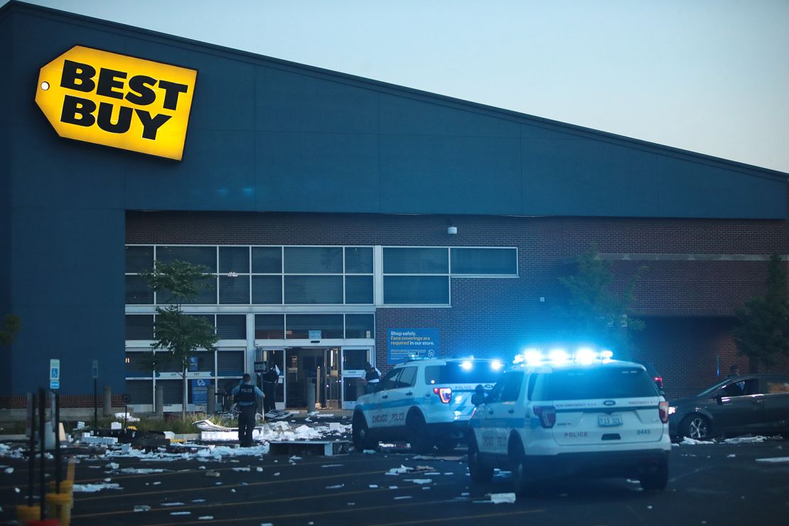 Police officers inspect a damaged Best Buy store on August 10, 2020, after parts of Chicago had widespread looting and vandalism.