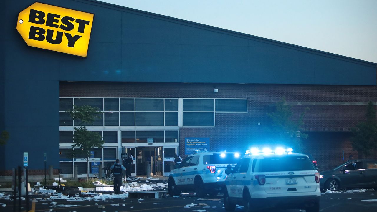 Police officers inspect a damaged Best Buy store on August 10, 2020, after parts of Chicago had widespread looting and vandalism.