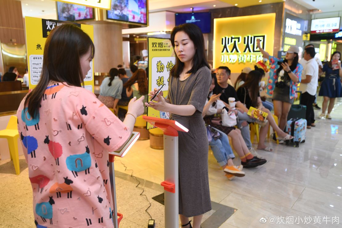 Customers weigh themselves in the popular Hunan restaurant chain Chuiyan Fried Beef, in the city of Changsha. Signs around the restaurant say "clean your plate" and "be thrifty and diligent."